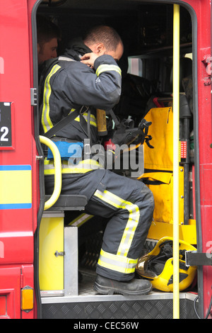 Fireman mette su apparecchi respiratori impostato sulla scena di un incendio Mayfair Foto Stock