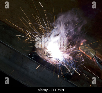 Calcolatore simbolico tema che mostra un paesaggio di saldatura con HDD, punto luce e scintille volanti in ambiente buio Foto Stock