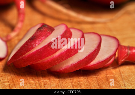 Rafano tagliato a fette su un tagliere di legno. Foto Stock