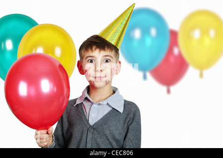 Ragazzo in compleanno hat con palloncini colorati su bianco Foto Stock