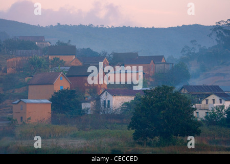 Case di villaggio nella nebbia mattutina, Madagascar Foto Stock