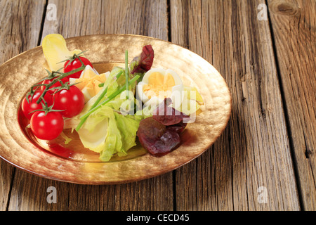 Ortaggi freschi e uova sode sulla piastra di oro Foto Stock