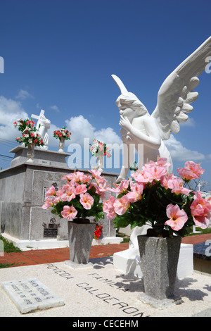 Statua dell'Angelo sulla tomba decorata con fiori rosa nel cimitero di Parita , Provincia di Herrera , Penisola di Azuero, Panama Foto Stock