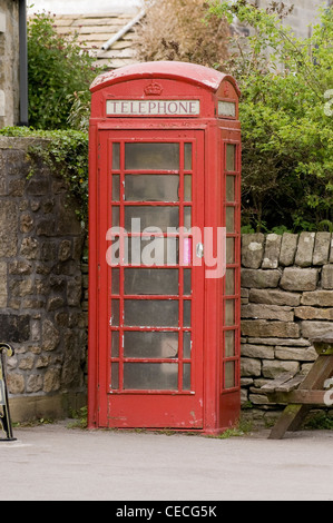 Tradizionale, iconico, telefono rosso box (kiosk n. 6 o K6) una comodità nel villaggio rurale (sporco vetri) - Burnsall, North Yorkshire, Inghilterra, Regno Unito. Foto Stock