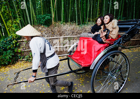 Due donne equitazione in un rickshaw, Giappone Foto Stock