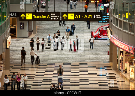 Passeggeri a piedi attraverso la sala di transito nel terminal 3 dell'Aeroporto Changi di Singapore Foto Stock