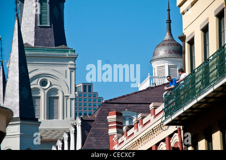 Due uomini su un balcone che si affaccia su piazza Jackson con la St Louis Cathedral in background Foto Stock