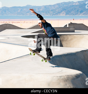 Guidatore di skateboard suona presso la spiaggia di Venice Skate Park, Los Angeles. Foto Stock