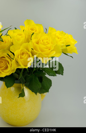 Tagliare rose giallo in una brocca giallo Foto Stock