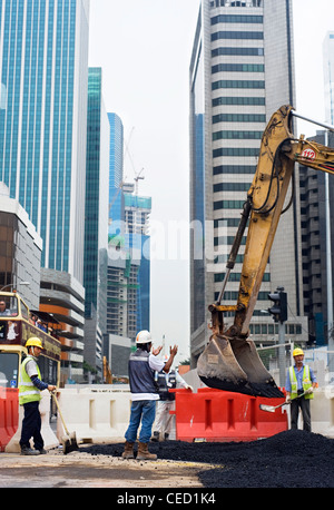 Lavoratori riparazione di strade su quello della città di Singapore street Foto Stock
