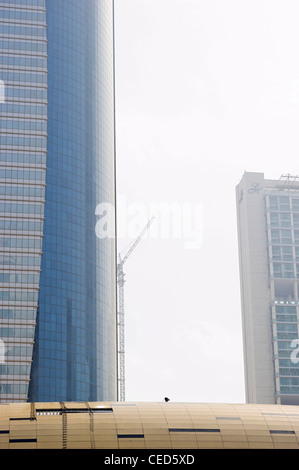 Scala, il confronto delle dimensioni, dimensioni, un lavoratore sul tetto di una stazione della metropolitana nella parte anteriore del grattacielo e Dubai Foto Stock