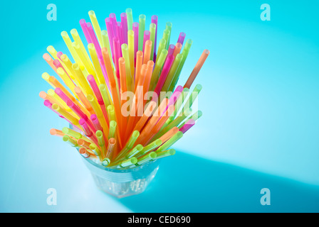 Flessibile multicolore cannucce in vetro su sfondo blu. Foto Stock