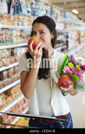 Donna ispanica odore di frutta in negozio di alimentari Foto Stock