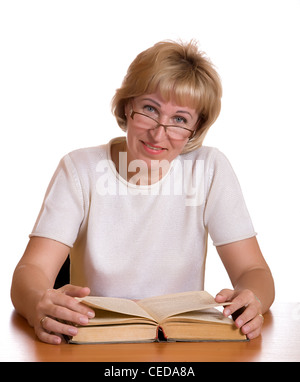 La donna matura con libro dietro un tavolo su sfondo bianco Foto Stock