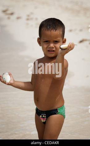 Little Boy tenendo il pesce ha catturato in un'acqua in Playa del Flamenco , isola di Cayo Coco, Ciego de Avila provincia, Cuba Foto Stock