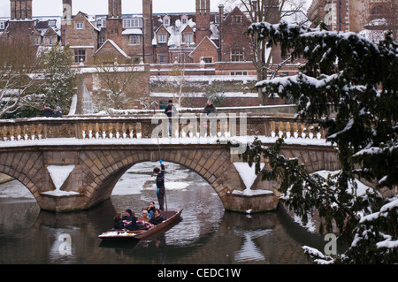 Punting Cucina sotto il ponte in inverno la neve. Cambridge. In Inghilterra. Foto Stock