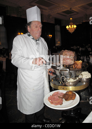 Maestro intagliatore preparare un arrosto di manzo piatto al tavolo di Simpson-nel-Strand, Londra, Inghilterra 111230 x1568 Foto Stock