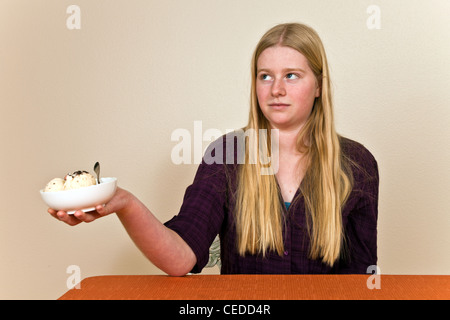 Ragazza adolescente con malsano atteggiamento verso il cibo si rifiuta di mangiare il gelato dessert. Signor © Myrleen Pearson Foto Stock