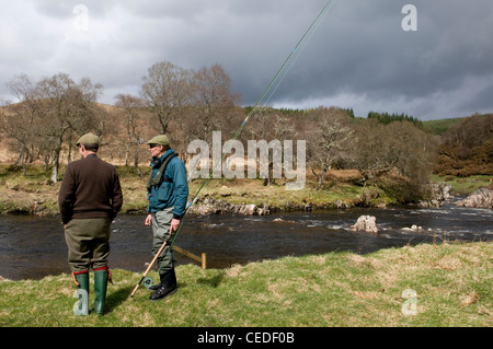 I pescatori in piedi sulla banca del fiume Oykel, Sutherland, Scotland, Regno Unito Foto Stock