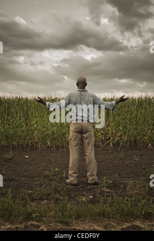 African American Farmer in piedi in campo con le braccia aperte Foto Stock