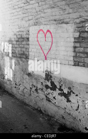 A forma di cuore spray-dipinta su un muro di mattoni in un vicoletto di Derby, Regno Unito Foto Stock