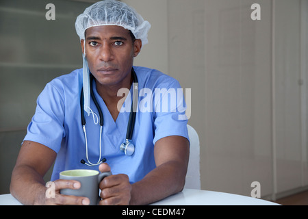 Medico nero in frega e cappuccio chirurgico Foto Stock
