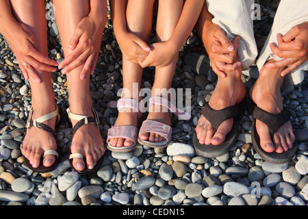 Sacco di gambe e le mani sulle pietre. famiglia con ragazza Foto Stock