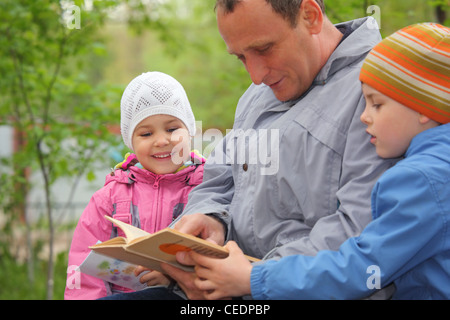 Padre legge libro per bambini, concentrarsi sulla bambina Foto Stock