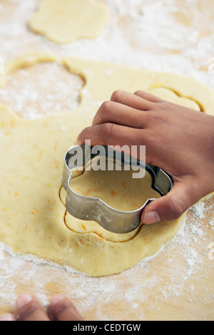 Rendendo la calendula cookie, bambino la mano utilizzando cookie cutter Foto Stock