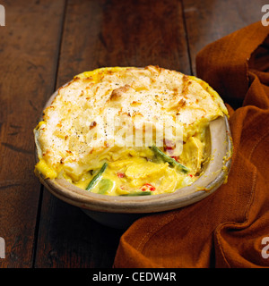 Vegetali e torta di pollo condito con le patate in una teglia da forno su una superficie di legno, close-up Foto Stock