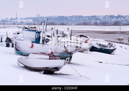 Barche da pesca ormeggiate sulla riva del fiume Rother Segala Harbor East Sussex Regno Unito in inverno dopo la nevicata Foto Stock