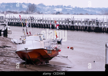 Barche da pesca ormeggiate sulla riva del fiume Rother Segala Harbor East Sussex Regno Unito in inverno dopo la nevicata Foto Stock