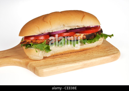 Rotisserie fette di pollo sandwich sottomarino con lattuga, pomodori e cipolle insalata su legno deli scheda su sfondo bianco. Foto Stock