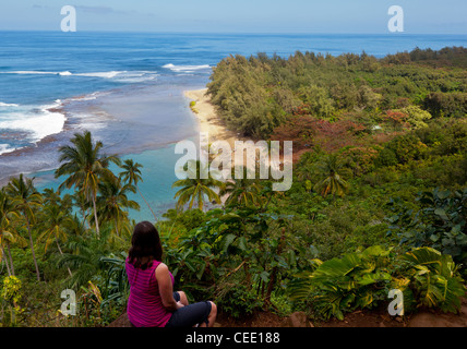Escursionista femmina che si affaccia Kee spiaggia da Kalalau Trail sulla costa di Na Pali di Kauai, Hawaii Foto Stock