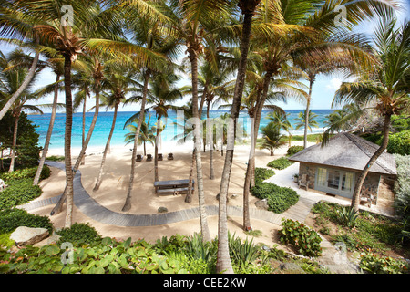 Isola paradiso spiaggia privata esclusiva Mustique Caraibi palme appartato non persone cielo sabbia mare deserto sole sole oceano amaca blu Foto Stock