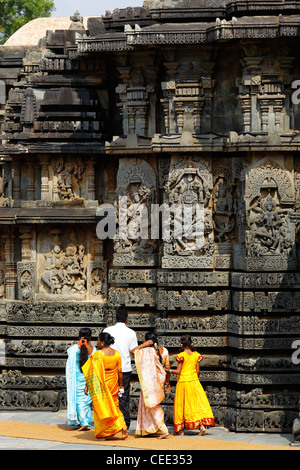 Indian womans in abiti tradizionali visitando il Tempio Hoysaleswara, un tempio dedicato al dio indù Shiva, Halebeedu, Karnataka Foto Stock