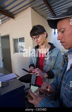 Volunteer rende la chiamata telefonica per famiglia in Honduras per l uomo che ha invano cercato di Cross Border per USA Foto Stock
