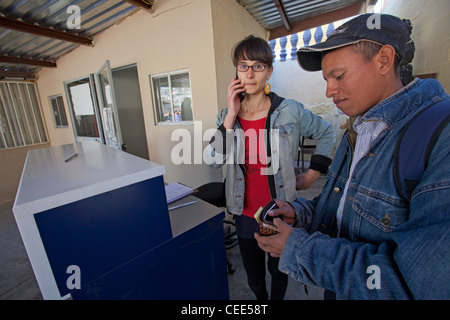 Volunteer rende la chiamata telefonica per famiglia in Honduras per l uomo che ha invano cercato di Cross Border per USA Foto Stock