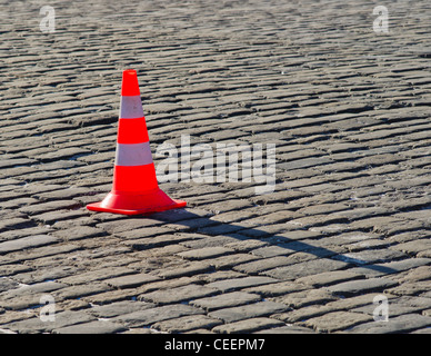 Red cono di sicurezza su una pavimentazione in ciottoli. Spazio libero per inserire il testo Foto Stock