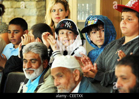 Folla mista di ragazzi della scuola e la comunità locale Foto Stock