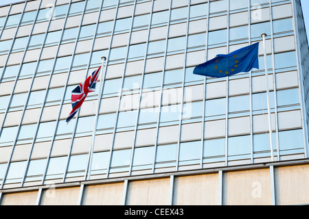 Bandiera del Regno Unito e bandiera UE insieme. Union Jack e l'Unione europea bandiere che sventolano fuori uffici a Nottingham, Inghilterra, Regno Unito Foto Stock