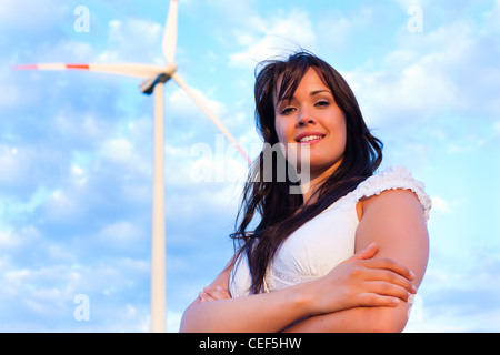 Giovane donna in piedi nella parte anteriore del mulino a vento e il blu del cielo Foto Stock