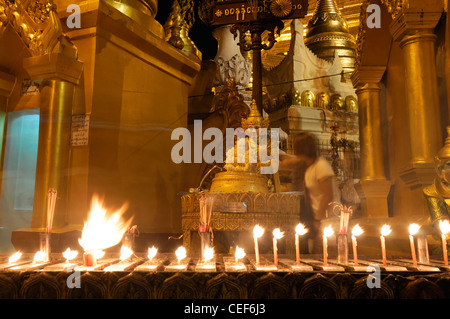 Devoto pellegrino pour versando acqua facendo offrendo alla statua del Buddha post planetari Shwedagon pagoda myanmar notte le ore notturne Foto Stock