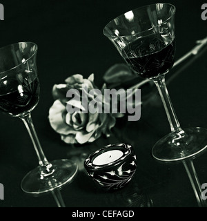 Due bicchieri di vino rosso con una rosa e una candela Foto Stock