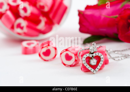 Serie di San Valentino, il Diamante pendente e caramelle con rose su sfondo bianco Foto Stock