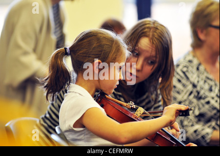 Un insegnante di musica dà lezioni di violino per 7 anno vecchia ragazza in una scuola primaria Foto Stock
