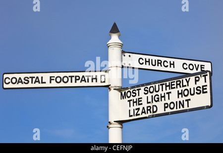 Traditional direction signpost to coastal path and most southerly point of Britain against blue sky. Lizard Cornwall England UK Foto Stock