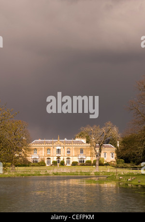 Great Missenden - Missenden Abbey - sun accesa sotto nuvole temporalesche - riflessa in un lago Foto Stock