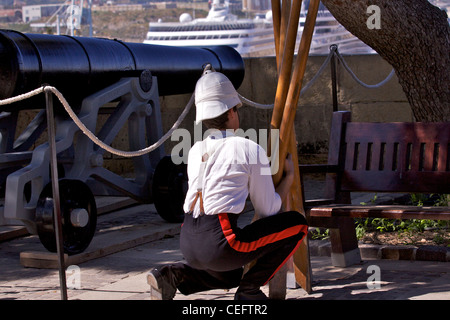 Un soldato prepara il cannone restaurata nella parte superiore Barracca Gardens per il quotidiano la cottura a mezzogiorno a La Valletta Foto Stock