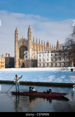 Punting lungo il fiume Cam in inverno la neve con Kings College Chapel per la parte posteriore. Cambridge, Inghilterra. Foto Stock